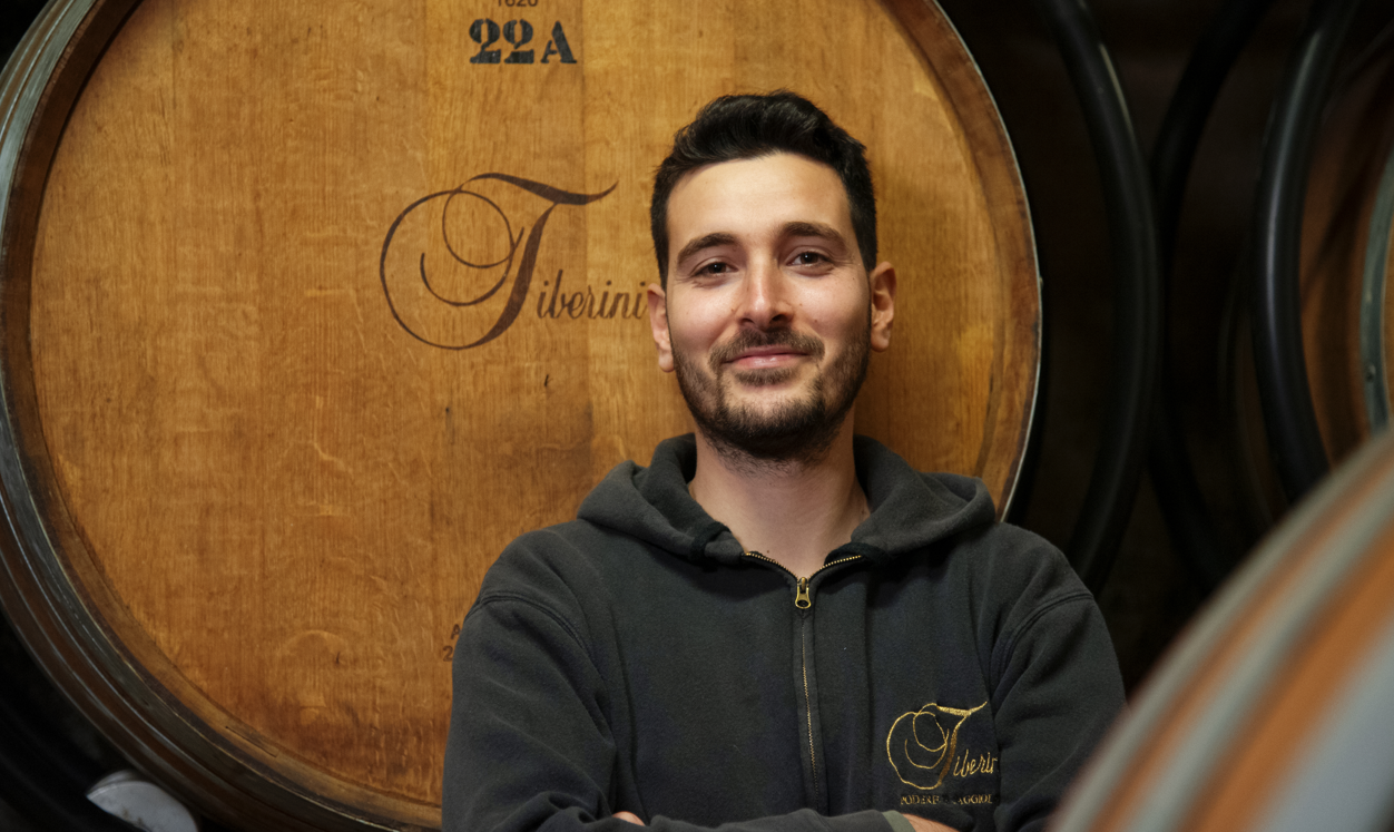 Tiberini ritratto davanti ad una botte di vino